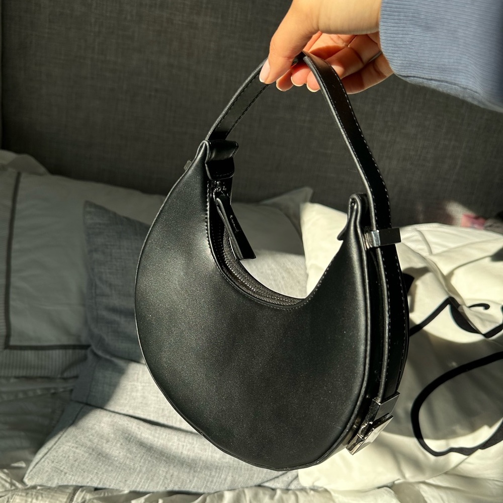 Black solid color crescent moon shoulder bag.
